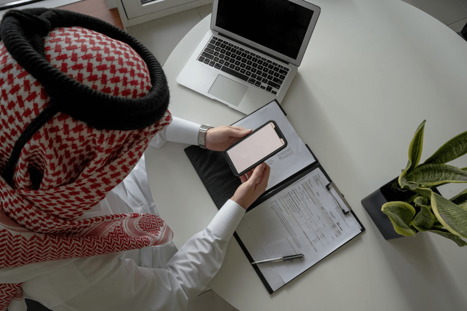 A man sitting in his office with a report on a clipboard - (Credits Unsplash)