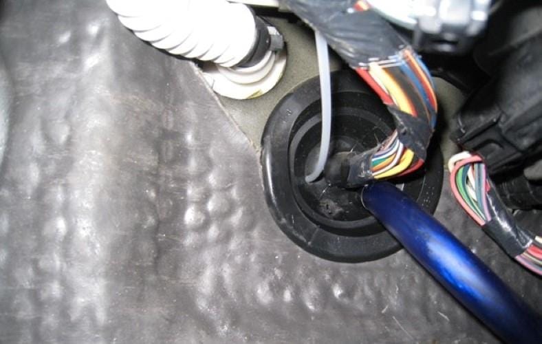 Image of positive amp wire pushed through firewall grommet