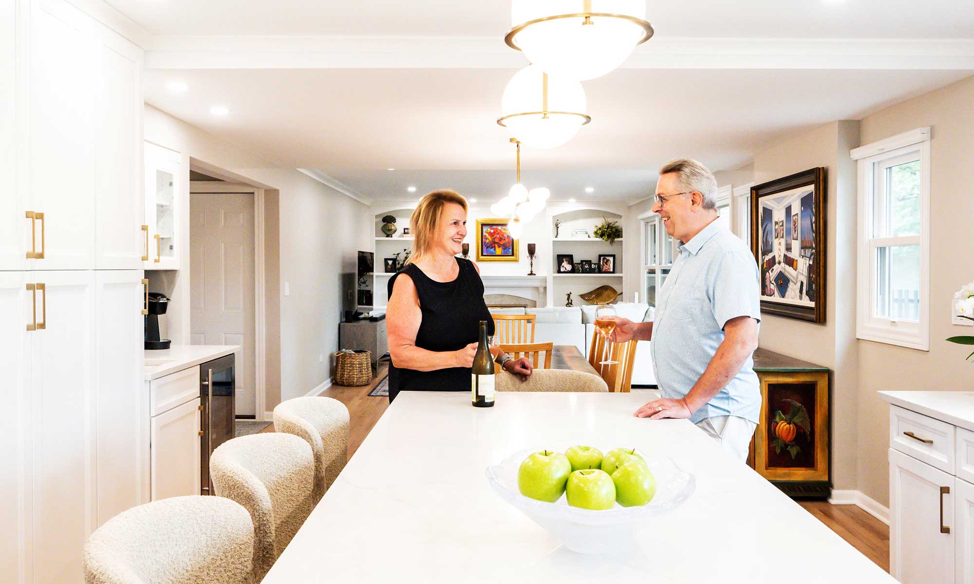 A husband and wife standing in a kitchen