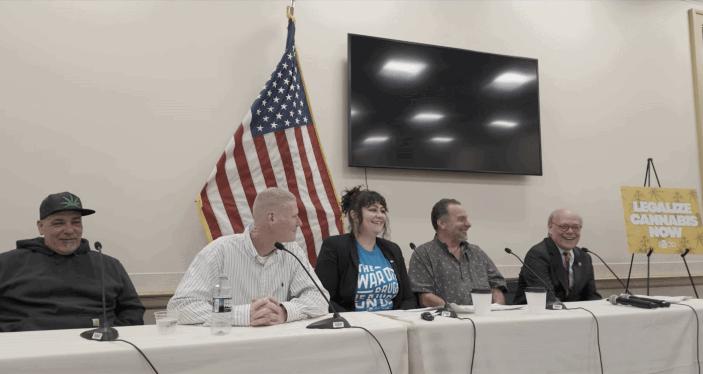 Panel discussion at SSDP event with diverse speakers and American flag.