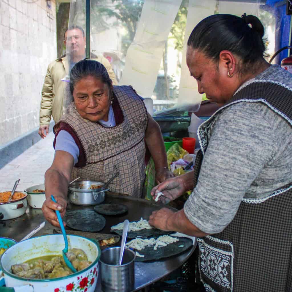 Street vendor preparing quesadillas during the Food Hood Tours route.