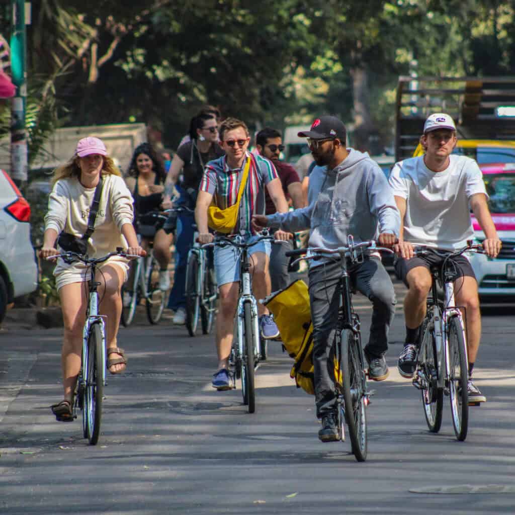 Guests biking through tree-lined streets in Roma Norte with Food Hood Tours