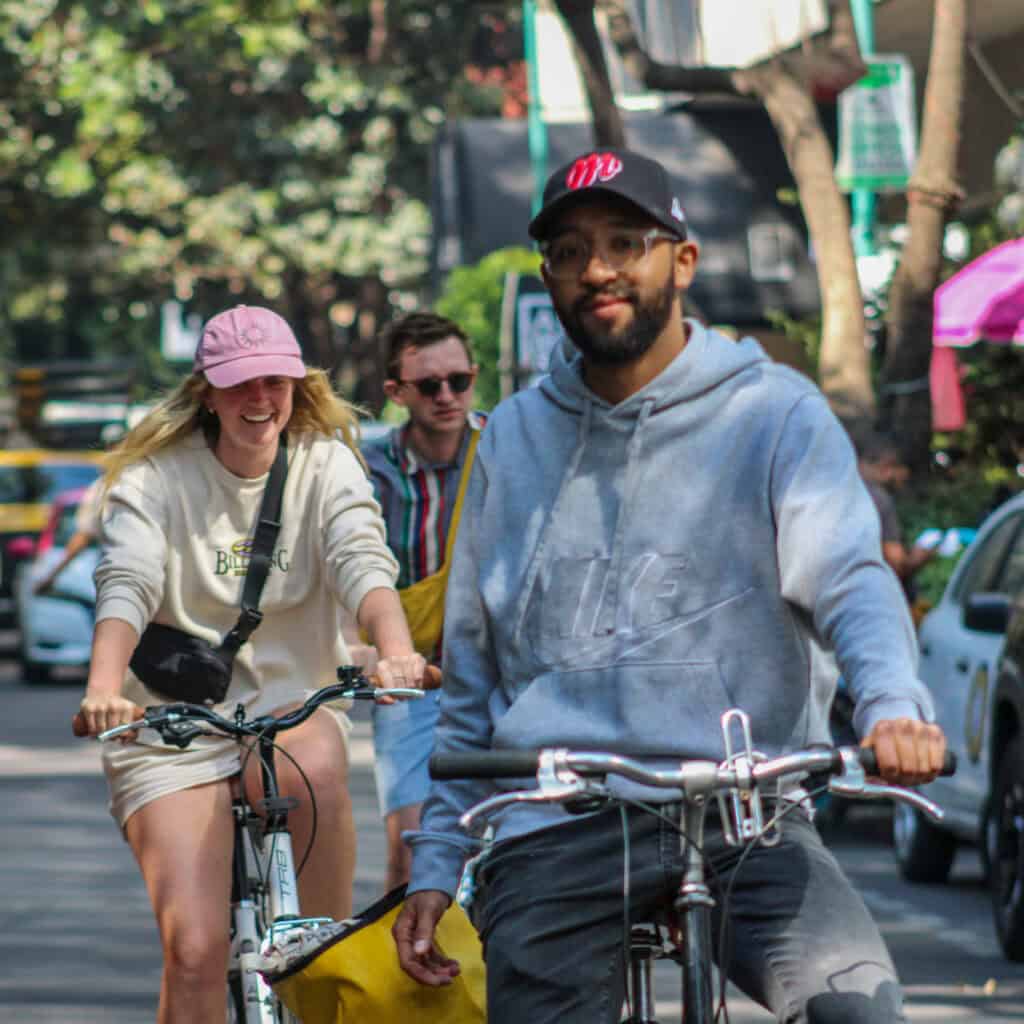 Cyclists riding through Roma Norte during a street food bike tour in Mexico City.