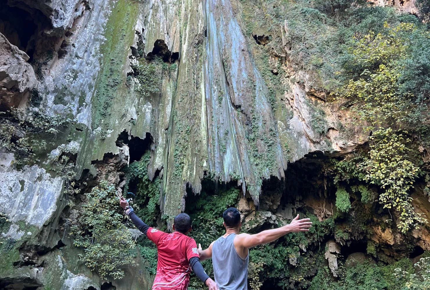 Travelers taking photos in front of the giant cascade waterfall in Akchour