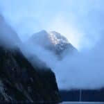 Mitre Peak rising above Milford Sound with waterfalls and rainforest.