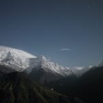 Night sky over snow-capped mountains in Fiordland National Park, New Zealand.