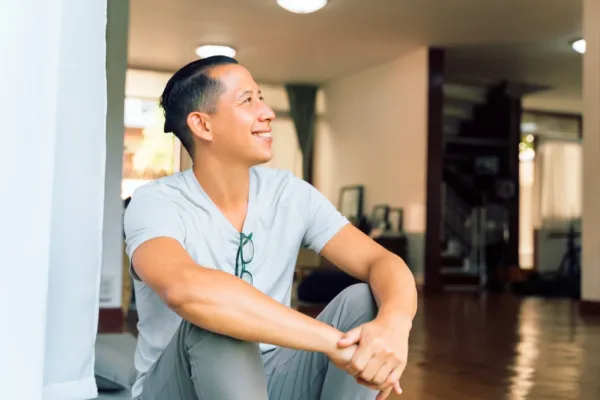 Man sitting looking into distance smiling in doors