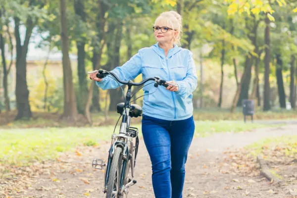 Woman walking with her bike in woods
