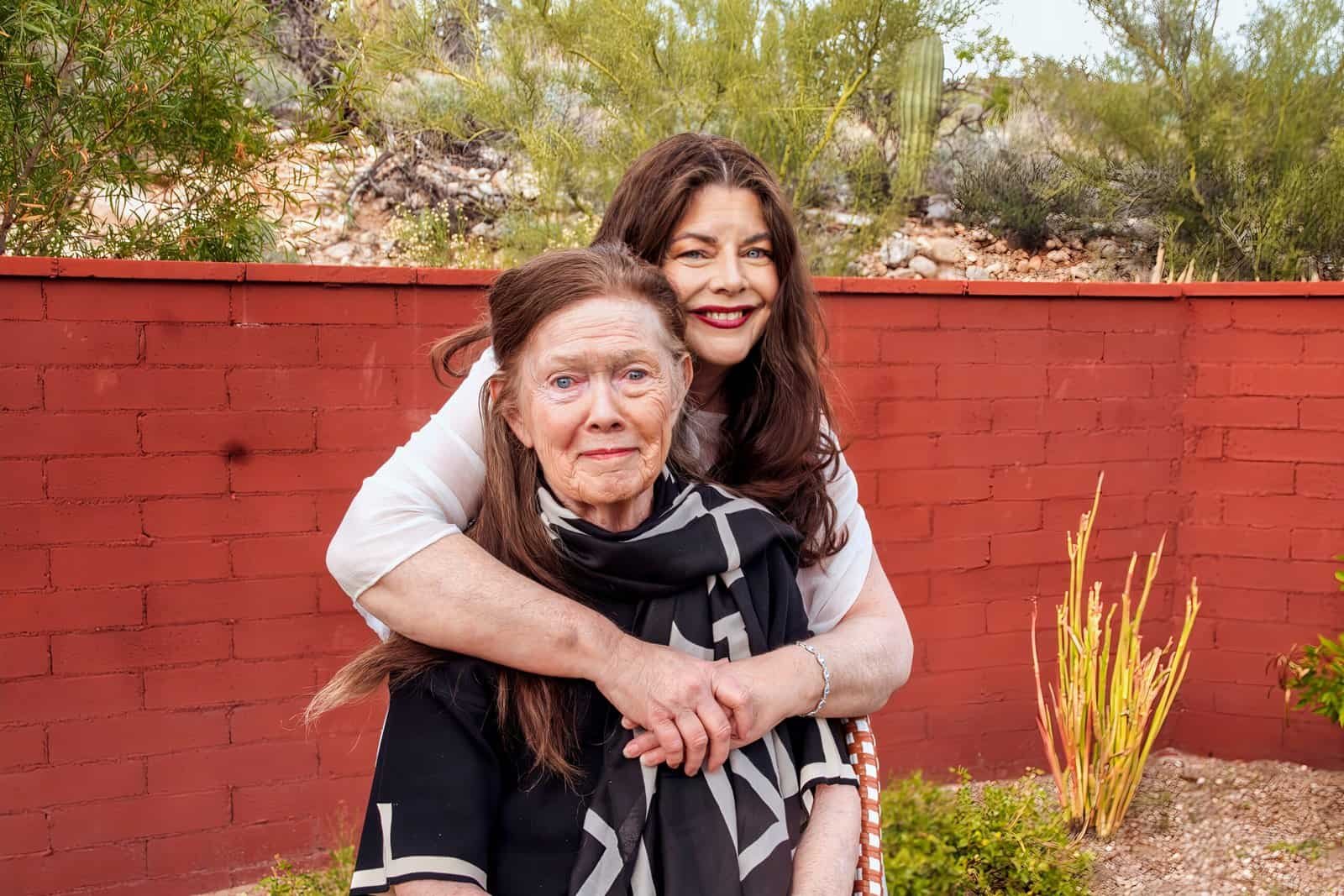 Joyful family bonding scene featuring two women embracing in a lush garden.