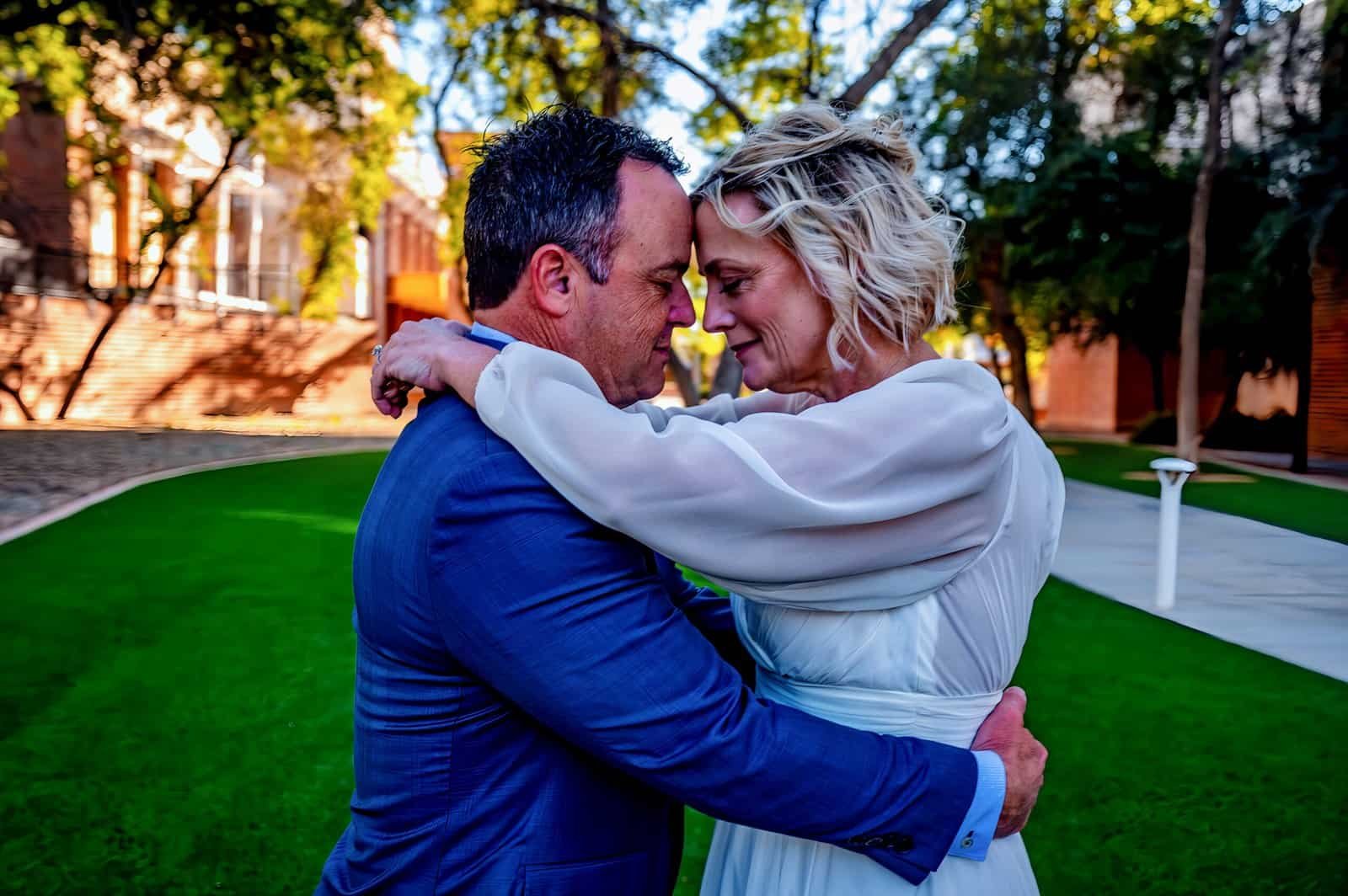 A romantic couple shares an intimate embrace in a scenic outdoor setting, highlighting love and emotional connection.