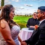Bride and groom exchanging vows during outdoor wedding ceremony.