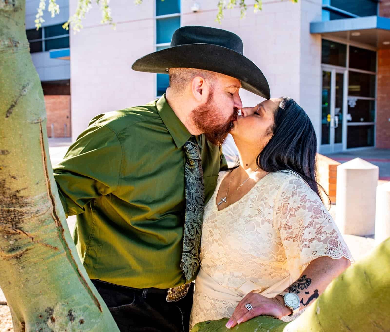 A romantic moment captured of a couple kissing outdoors, highlighting love and connection in a natural environment.