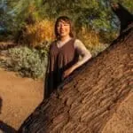 Smiling woman enjoying a sunny day outdoors, capturing joyful moments in nature.