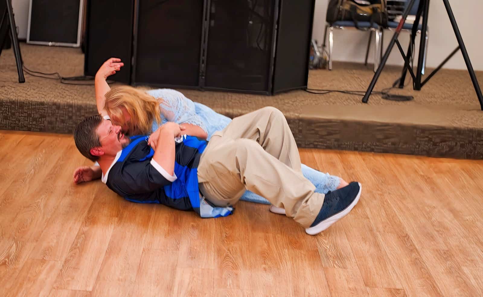 A couple sharing a joyful dance on the wooden floor at a special event, capturing a memorable moment of love and happiness.