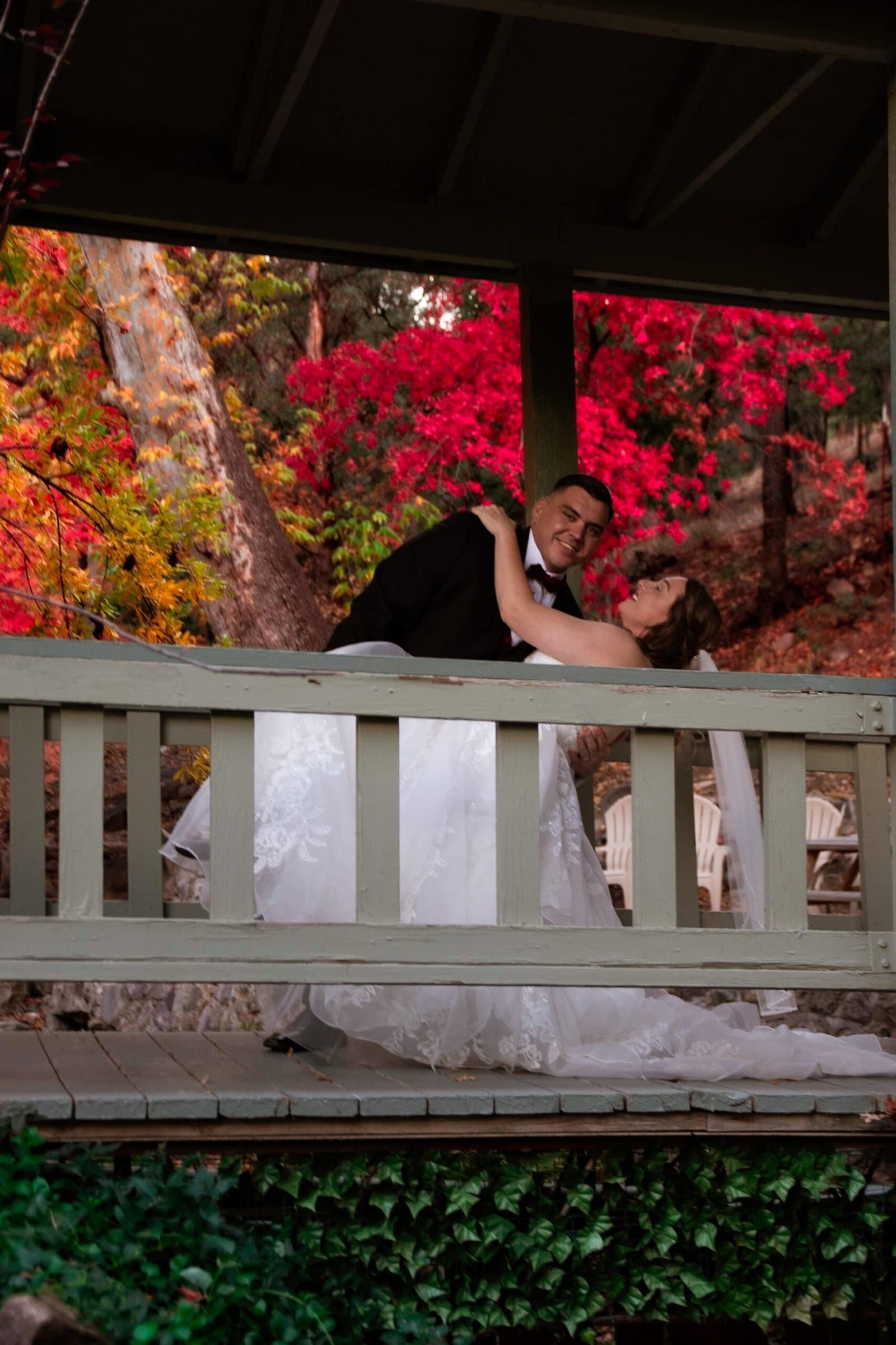 Romantic moment of a bride and groom dancing outdoors on a decorated gazebo during autumn.