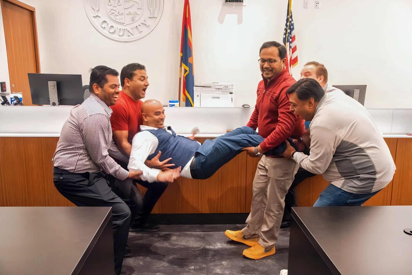 Men having fun and celebrating together during a community event at the county office.