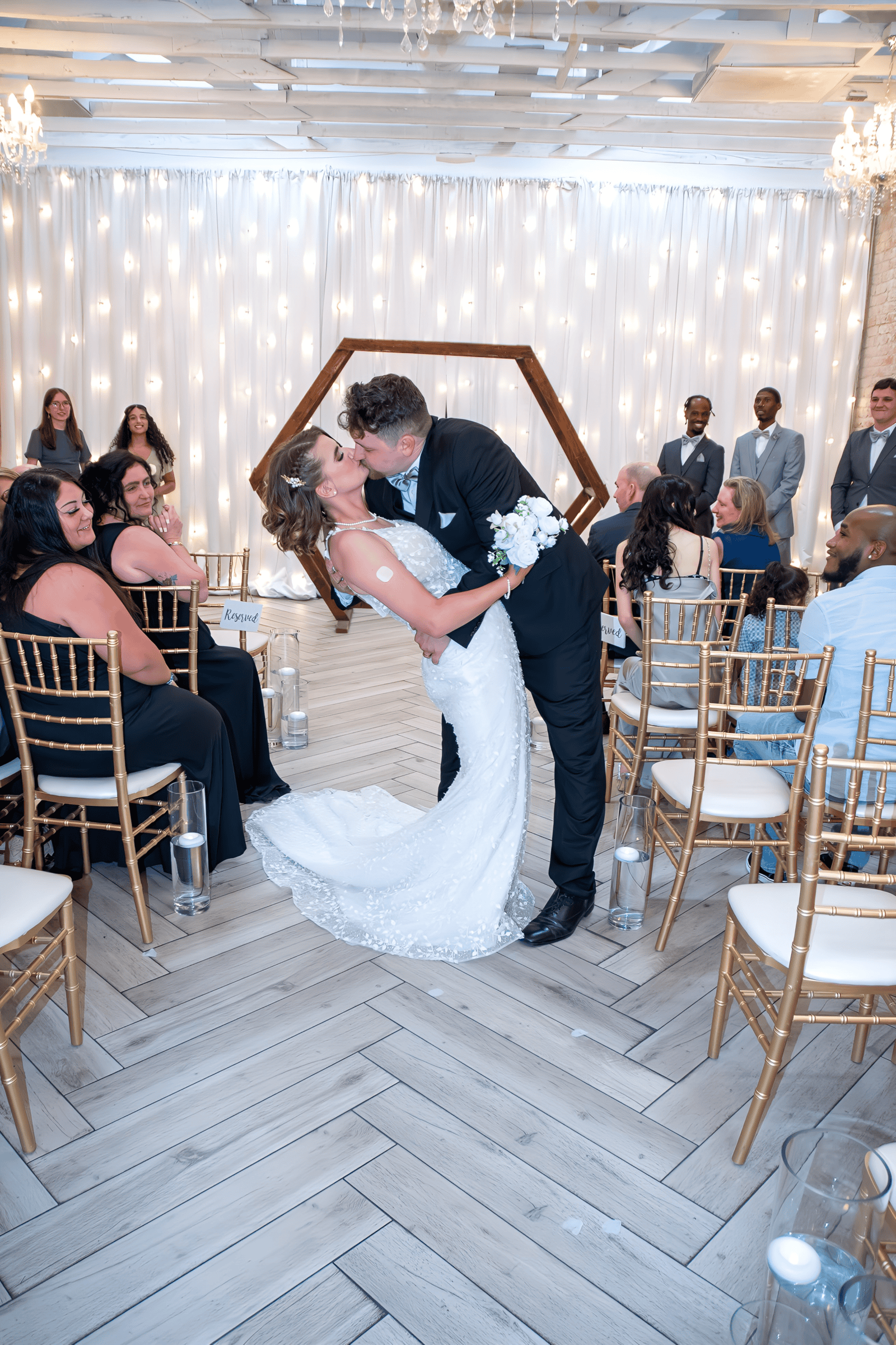 Romantic wedding moment with couple dancing, surrounded by guests and fairy lights, capturing a special celebration.