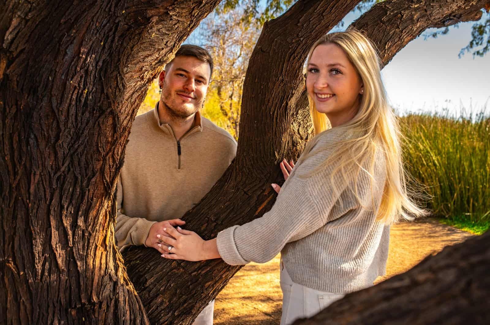 A joyful couple sharing a special moment outdoors, surrounded by trees and natural beauty, capturing love and happiness.