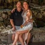 Wedding couple enjoying a scenic outdoor setting with natural stone backdrop.