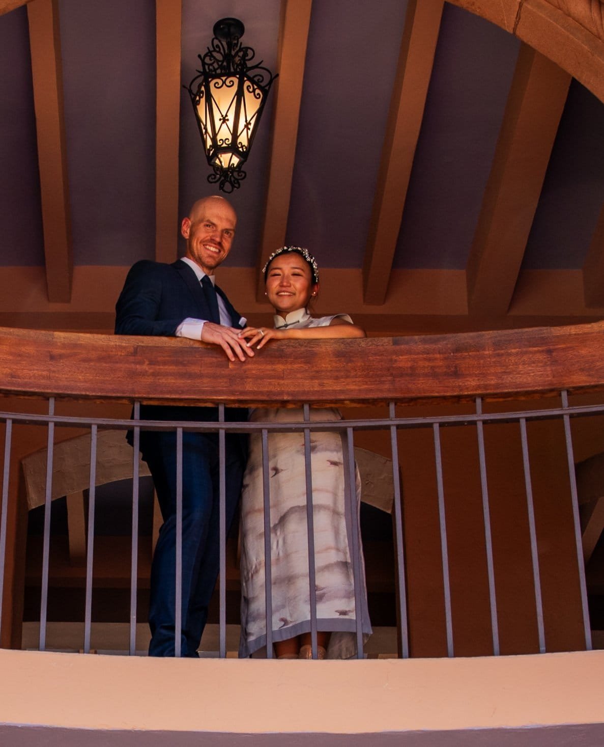 Joyful bride and groom celebrating their wedding day on a charming balcony setting.