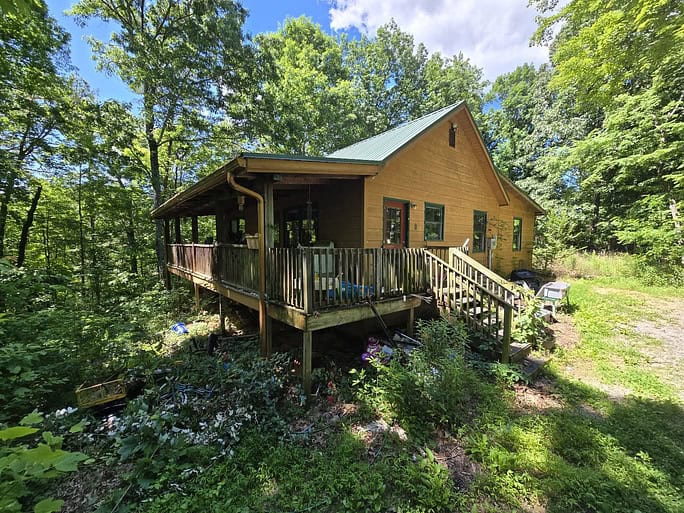 A cabin in the woods with a deck and porch Speedy Turtle