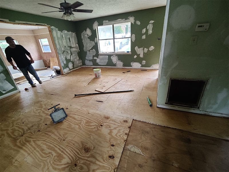 A construction man working inside a house with green walls. Speedy Turtle