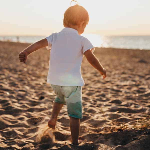 a child dancing on the sand on the beach