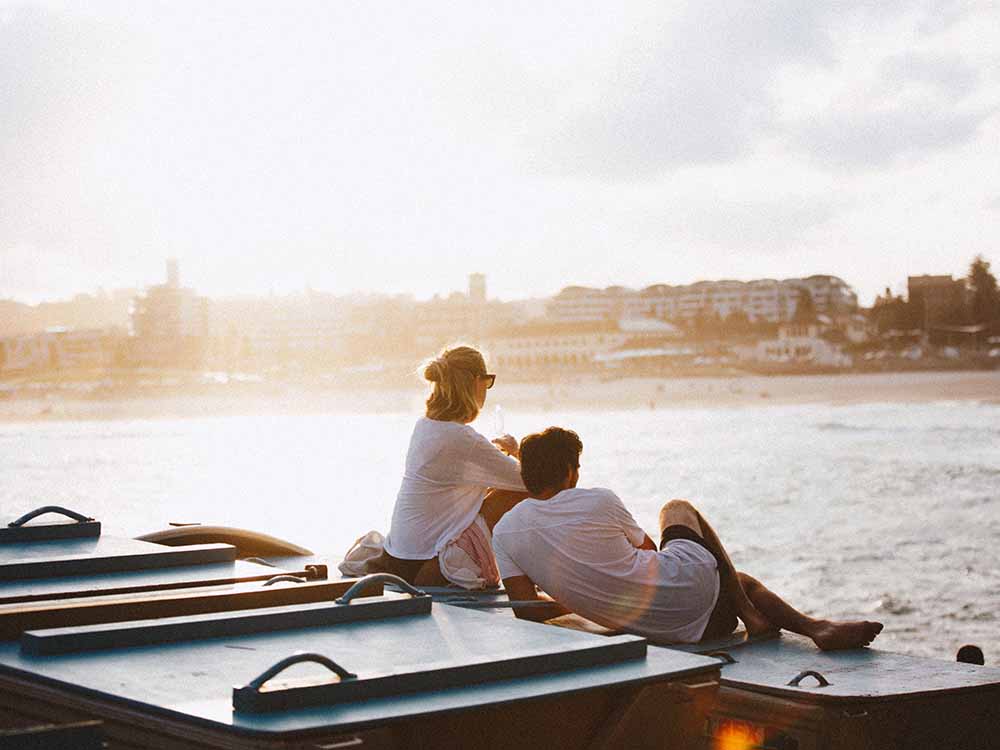 2 people sitting on a boat overlooking Bondi Beach