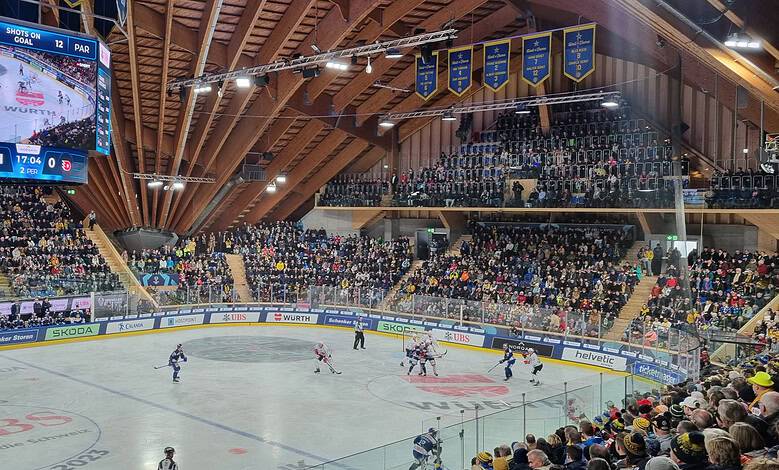 Exciting ice hockey game at the sports arena with enthusiastic fans, digital scoreboards, and team players in action, showcasing premier sports competition and fan engagement.