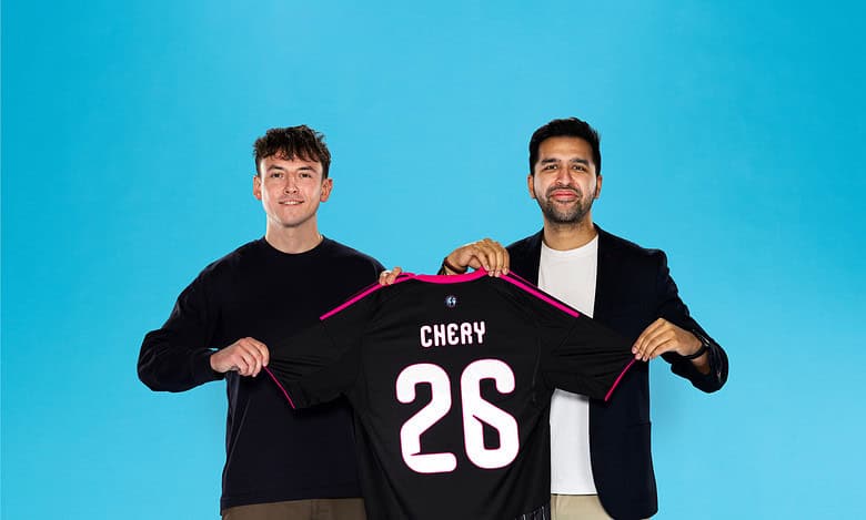Football fans holding a Chelsea jersey with the number 26, symbolising sports passion and community support.