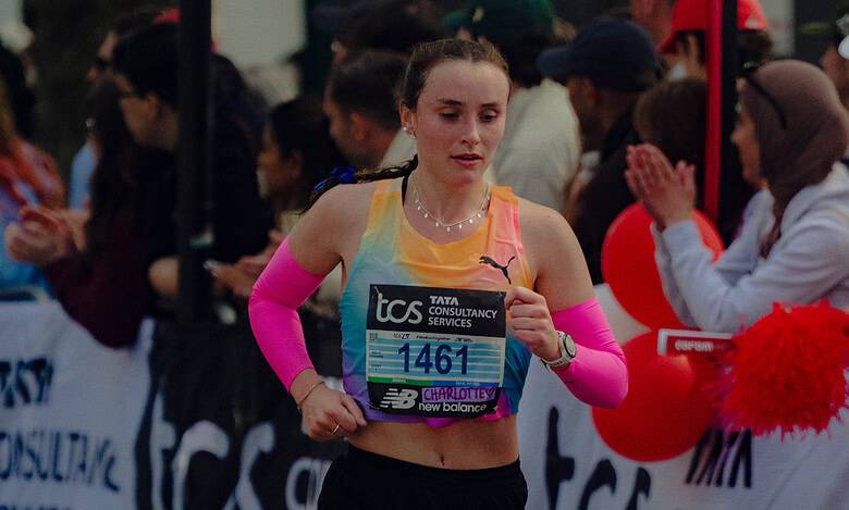 A female runner participating in the London Marathon 2026, wearing a colourful athletic outfit and pink running shoes, with a focused expression as she approaches the finish line.