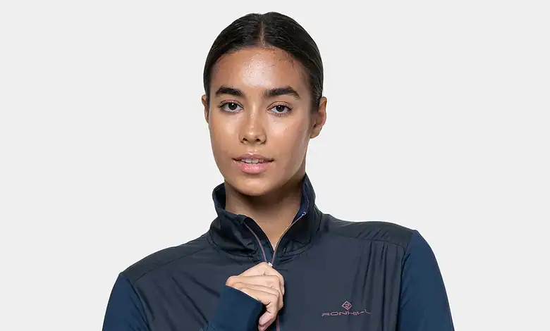 Female athlete wearing a navy and dark blue sports jacket, showcasing activewear suitable for running or outdoor sports. Perfect for sports enthusiasts and fitness fans.