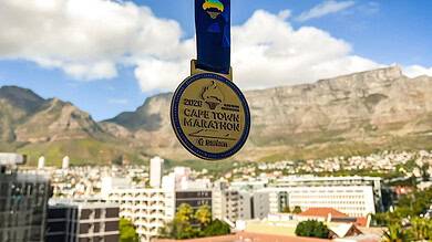Medal for the 2020 Cape Town Marathon hanging against a backdrop of Table Mountain and the city skyline, highlighting South Africa's iconic marathon event and scenic race route.