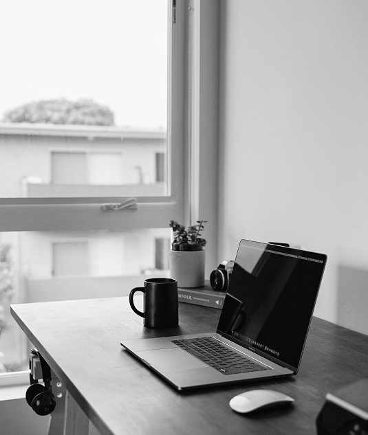 A desk with a mug and a laptop ready to contact