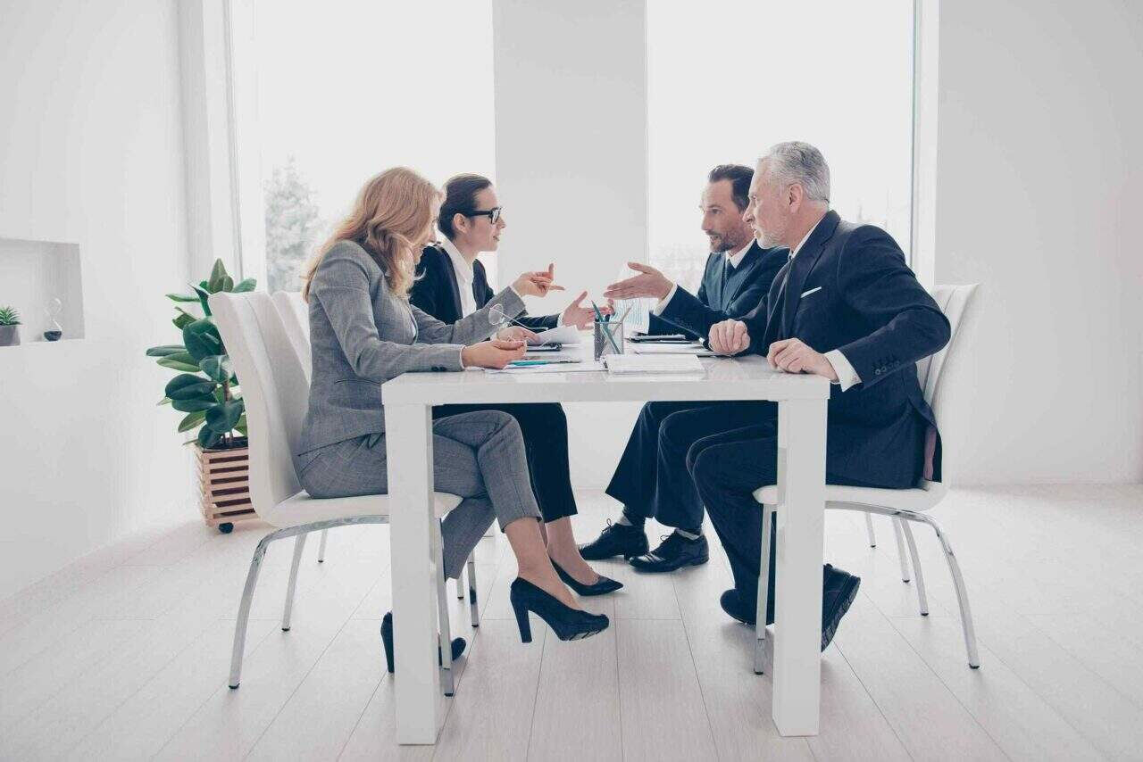 Team of professionals in a business meeting discussing strategies at a modern conference room, highlighting corporate consulting services.