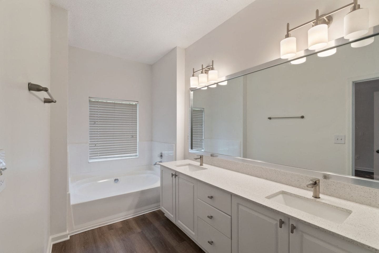 A bathroom with a white countertop and a large mirror.