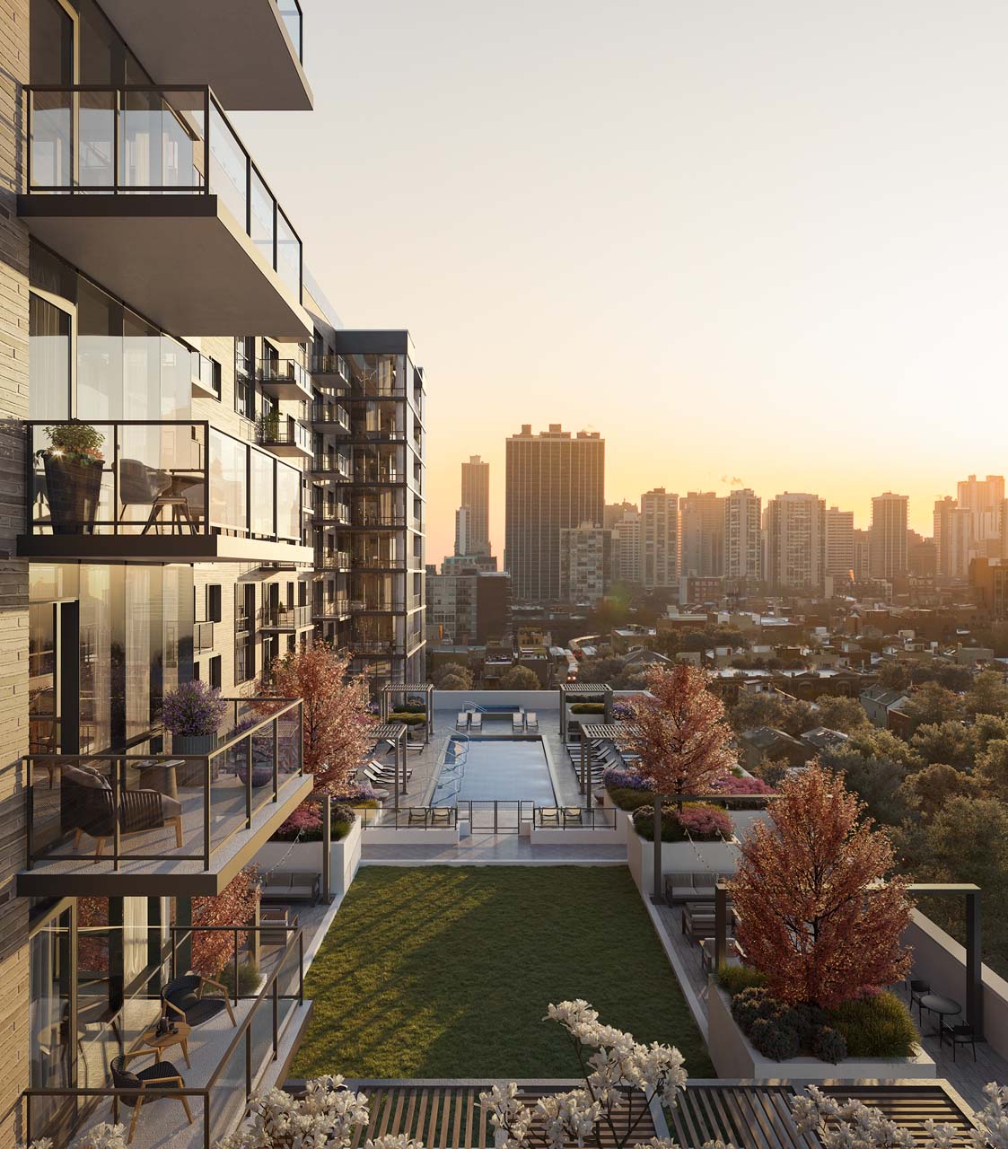 Modern Windsor North + Vine apartment building with glass balconies overlooks a landscaped courtyard and swimming pool, set against a city skyline at sunset. Trees with autumn foliage line the outdoor area.