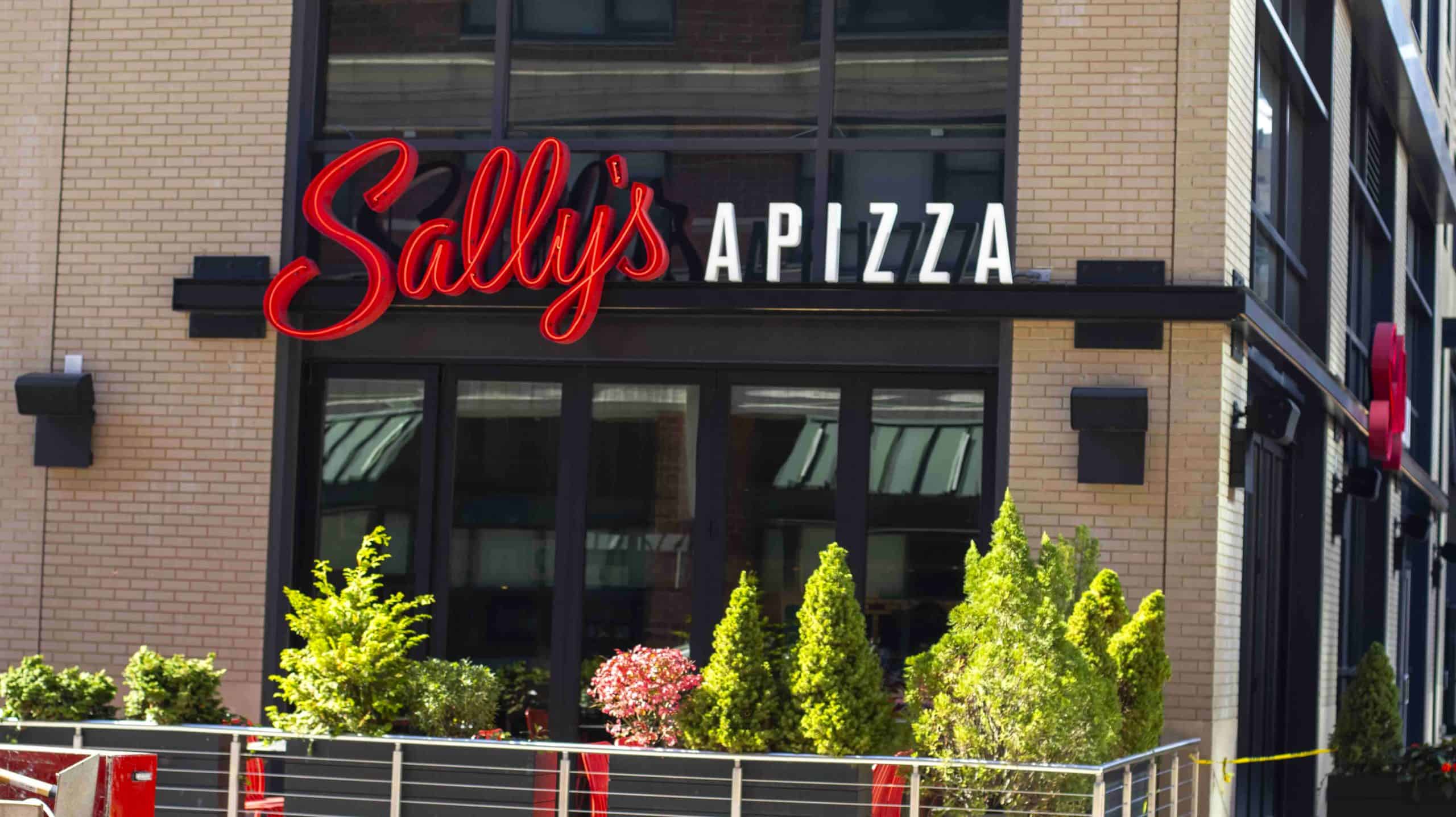 Custom architectural sign for Sally's Pizza with illuminated red and white lettering.