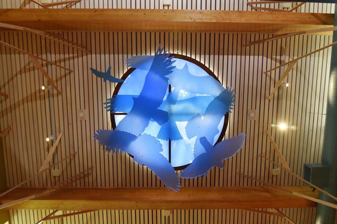 Modern blue bird sculpture with circular background in architectural signage display.