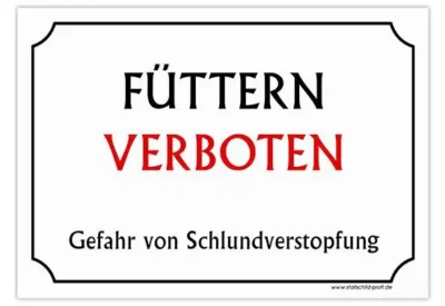 Eine Stallschild-Stalltafel „Füttern verboten – Schlundverstopfung“, auf der auf Deutsch „futtern verboten“ steht.