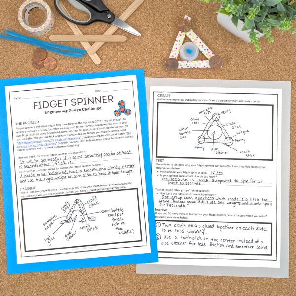 This image shows two worksheets titled "Fidget Spinner Design Challenge." The worksheets have been completed. There is also a DIY fidget spinner design in the image created from popsicle sticks, pennies, a pipe cleaner, and pennies.