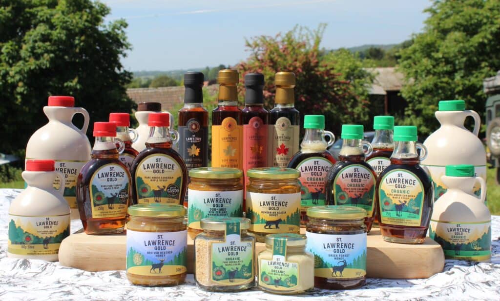 Full range of St Lawrence Gold On a table outdoors with trees behind and blue sky