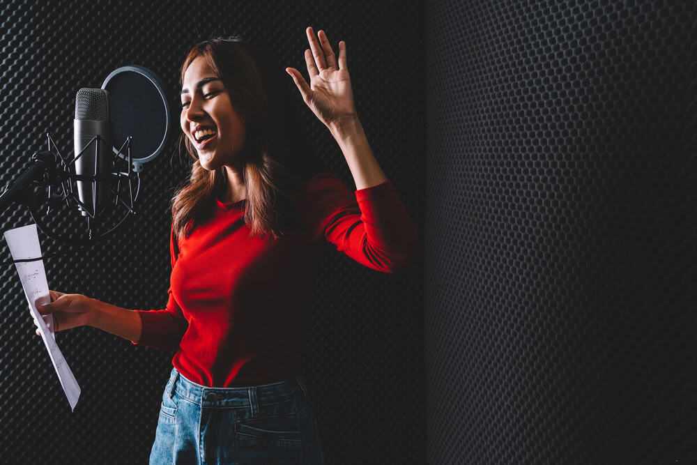 Young woman recording a song in a recording studio