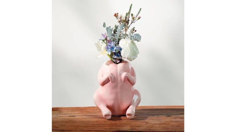 Cute ceramic rabbit vase filled with colorful fresh flowers on wooden surface.