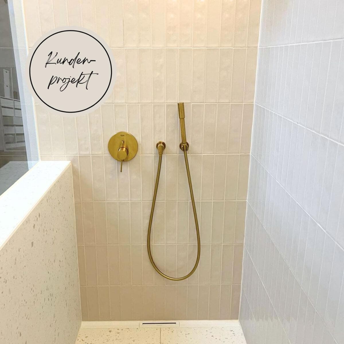 Dusche mit beigen Metro-Fliesen und Messing-Armatur