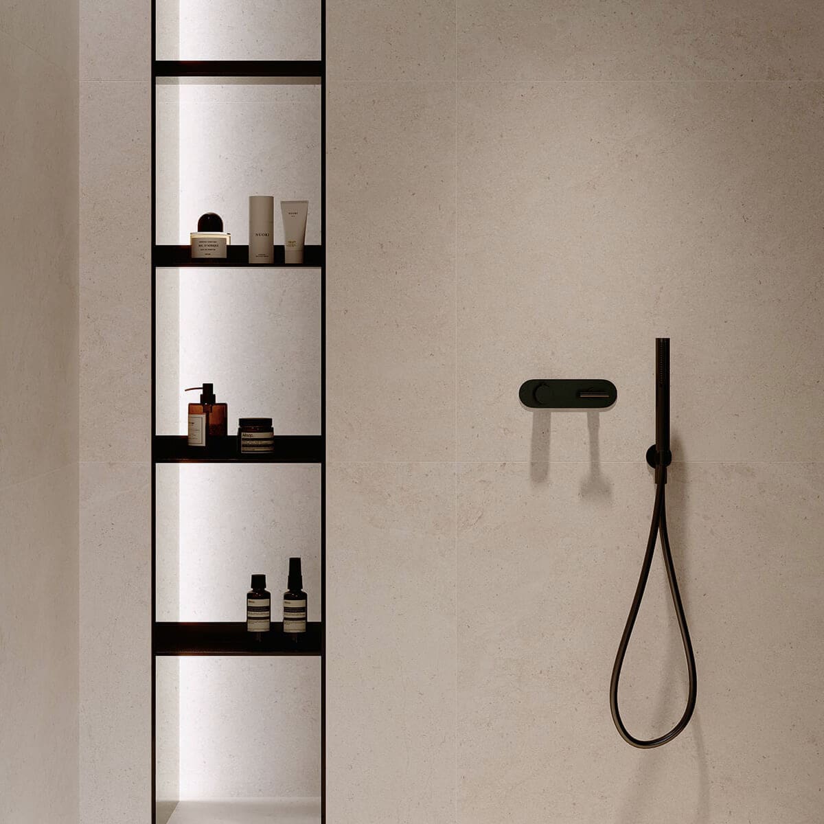 Bad mit beiger Fliese und schwarzen armaturen