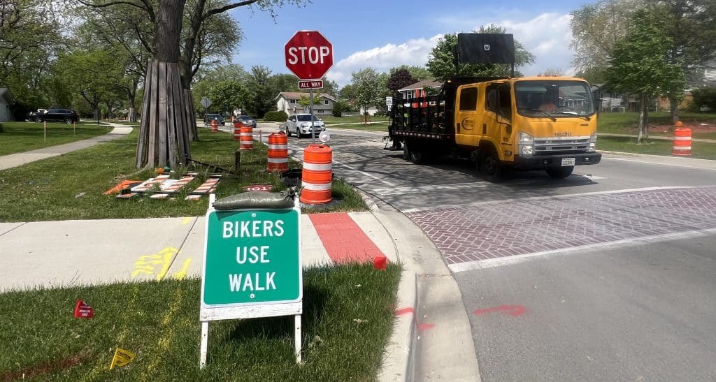 A sign implores that "bikers use walk" on Salem Drive in Schaumburg, as reconstruction of the street is underway in May 2025.