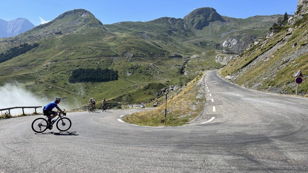 Looking at the downslope and upslope of a hairpin turn in a dry mountain range under a blue sky.