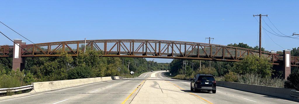 Vintage metal pedestrian bridge on suburban Chicago scenic highway during daytime