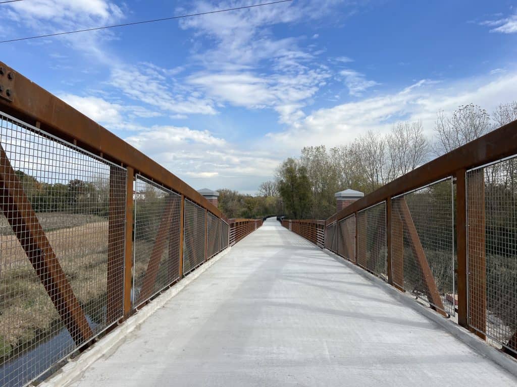 Scenic suburban Chicago bike trail on a sunny day with blue sky and trees in background.